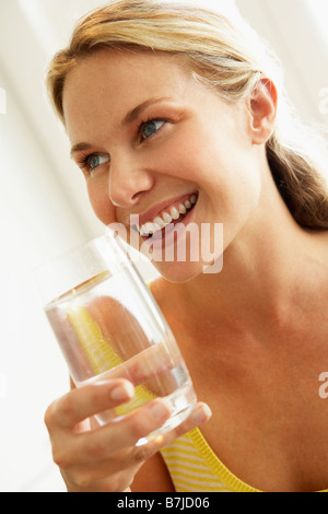 Junge Frau trinkt ein Glas Wasser Stockfoto