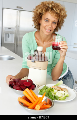 Mitte Erwachsene Frau macht frischen Gemüsesaft Stockfoto