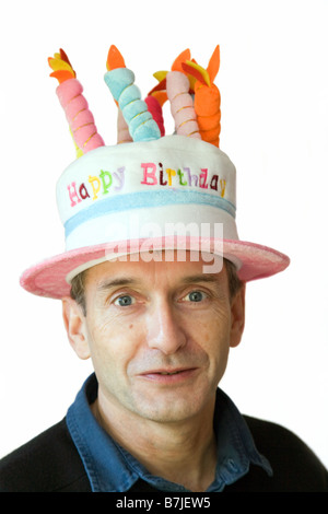 Hübscher Mann mittleren Alters in einem herzlichen Glückwunsch zum Geburtstag-Hut Stockfoto