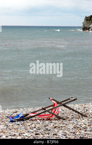Angeschlagenen Liegestühlen an einem einsamen Strand, Maifeiertag Bankfeiertag Dorset UK