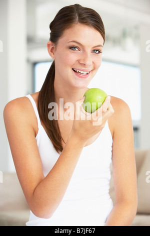 Junge Frau, die einen Apfel essen Stockfoto