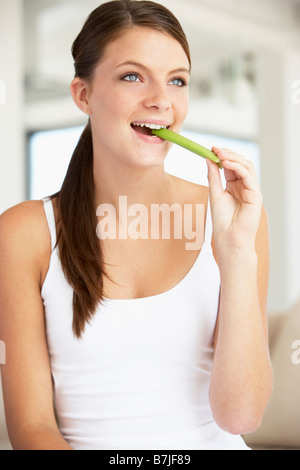 Junge Frau Essen Stangensellerie Stockfoto