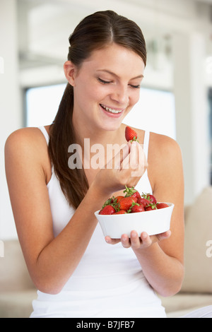 Junge Frau essen eine Schale mit frischen Erdbeeren Stockfoto