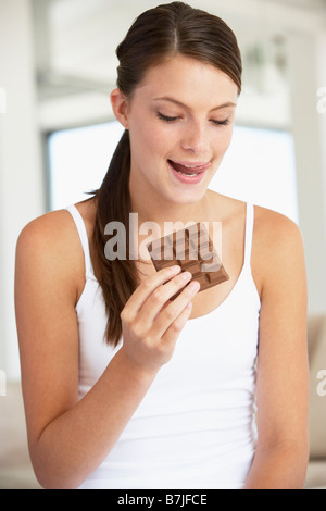 Junge Frau essen Schokolade Stockfoto