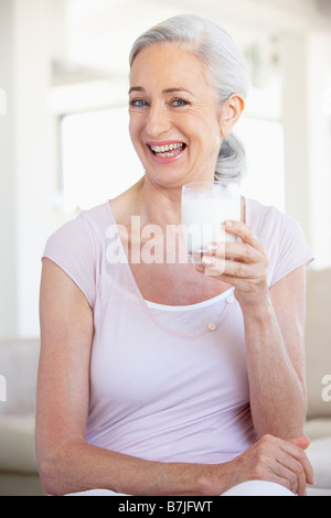 Ältere Frau trinkt ein Glas Milch Stockfoto