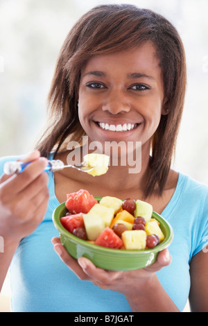 Teenager-Mädchen essen Salat von frischen Früchten Stockfoto