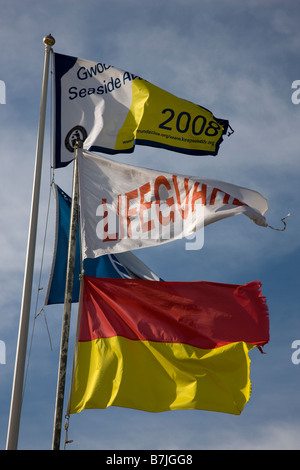 Rettungsschwimmer Fahnen und blaue Flagge Wasser Qualitätspreis fliegen über den Strand in Port Eynon Gower Stockfoto