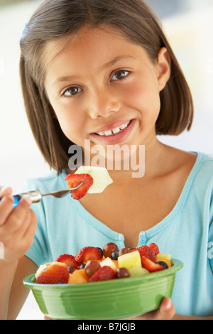 Mädchen essen eine Schale mit frischem Obstsalat Stockfoto