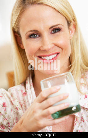 Mitte Erwachsene Frau Glas Milch, lächelnd in die Kamera halten Stockfoto
