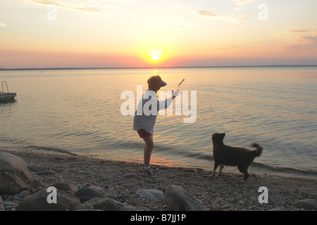 Frau mit Hund am Strand Clear Lake; Kanada, Manitoba, Riding Mountain National Park Stockfoto