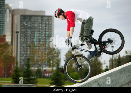 Profil von Jugend auf Mountainbike, Stadtturm im Hintergrund, Alberta, Calgary, Shaw Millenium Park Stockfoto