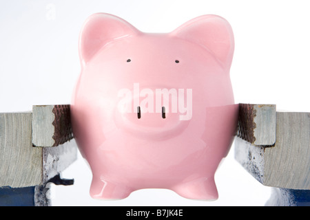 Piggy Bank In Rachen Vice vor weißem Hintergrund Stockfoto