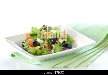 Griechischer Salat auf einem weißen Teller auf einer grünen gefaltete Serviette Stockfoto