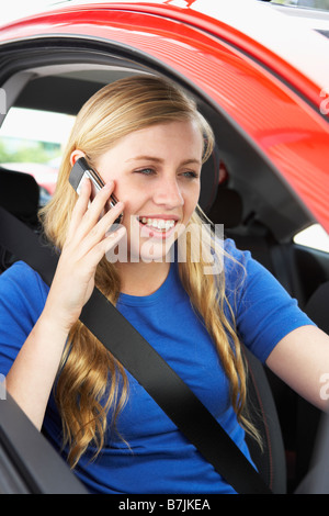 Teenager-Mädchen sitzen im Auto sprechen auf Handy Stockfoto