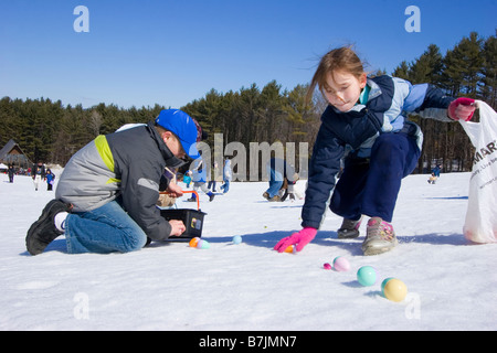 Zwei Kinder sammeln Plastik Ostereier im Schnee Stockfoto