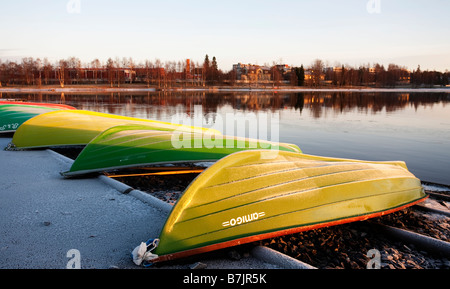 Umgedrehte grüne Fiberglas Ruderboote / Skiffs / Schlauchboote wurden am Flussufer in Oulujoki Finnland befahren und gelagert Stockfoto