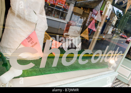 Ein großes Schokolade Schild im Fenster eine Chocolaterie mit Reihen von Ammer dahinter sprechen über ihr Eis zu verkaufen. Stockfoto