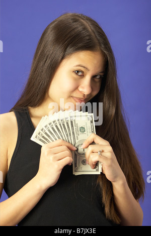 Eine hübsche junge Frau, die Vereinigten Staaten Geld schauen glücklich halten Stockfoto