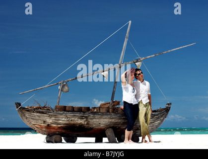 Junge Brautpaar posiert in der Nähe von altes Schiff am tropischen Sandstrand Stockfoto
