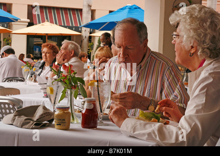 Älteres Ehepaar beim Mittagessen in einem Restaurant im Freien unter anderen Gäste. Stockfoto