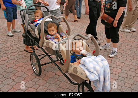 Drillinge 6 Monate alt draußen im Kinderwagen Stockfoto