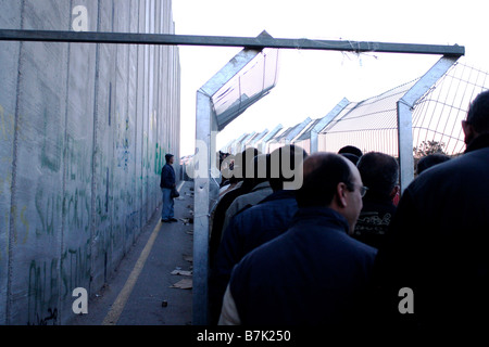 Palästinensische Männer warten am Bethlehem-Terminal bei Sonnenaufgang durch den Checkpoint und in Israel für Arbeit übergeben. Stockfoto
