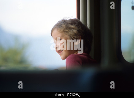 Junges Mädchen schaut Fenster des Zuges, wie sie entlang eilt Stockfoto