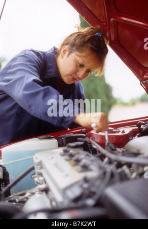 Hispanic weibliche Mechaniker arbeitet am Motor des Autos. Stockfoto