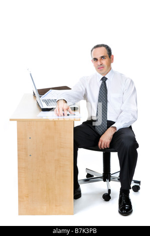 Ernsthaften Geschäftsmann sitzt an seinem Schreibtisch isoliert auf weißem Hintergrund Stockfoto