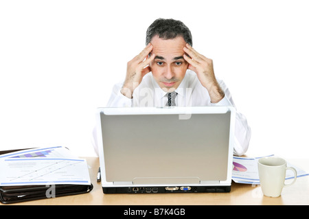Betonte Geschäftsmann sitzt an seinem Schreibtisch isoliert auf weißem Hintergrund Stockfoto