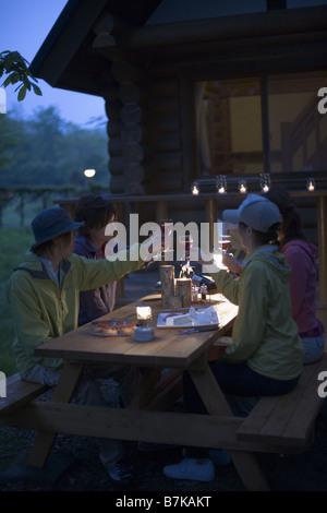 Gruppe von Jugendlichen sind chatten auf Campingplatz in der Abenddämmerung Stockfoto