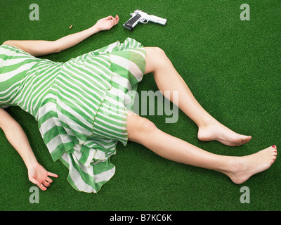 Frau mit Waffe am Boden liegend Stockfoto