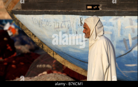 eine marokkanische Mann trägt eine traditionelle Djellaba gehen im Hafen von Essaouira Marokko Stockfoto