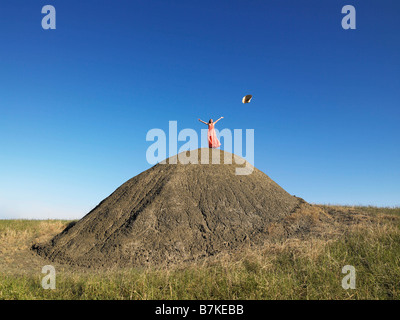 Frau auf Hügel werfen Hut Stockfoto