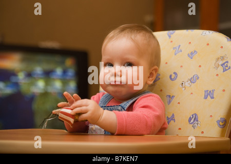 Acht Monate altes Baby im Hochstuhl sitzen Stockfoto