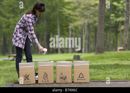 Frau Trowing Müll in den Mülleimer Stockfoto
