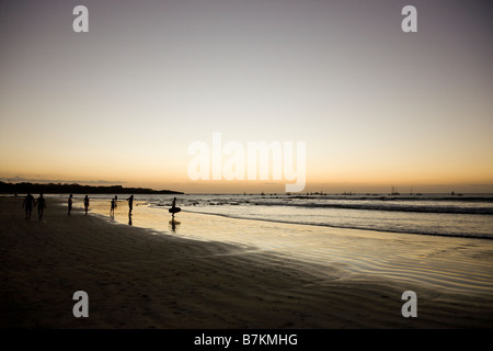 Surfer am Strand nach Sonnenuntergang am Playa Tamarindo in Guanacaste, Costa Rica. Stockfoto