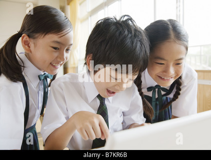 Grundschüler Blick auf laptop Stockfoto