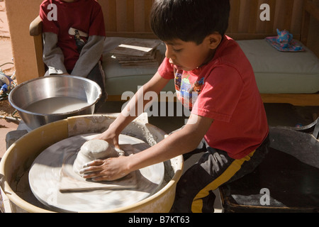 sechs Jahre alter Junge keramisches Stück auf einem Rad zu schaffen Stockfoto