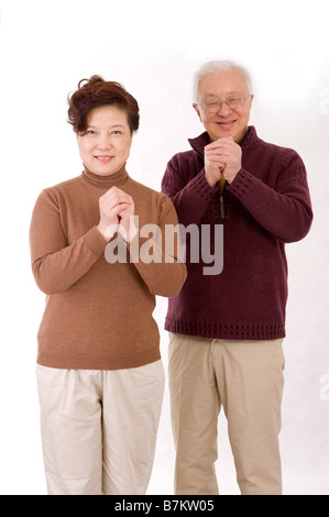 Älteres Ehepaar mit den Händen umklammert in die Kamera schaut Stockfoto