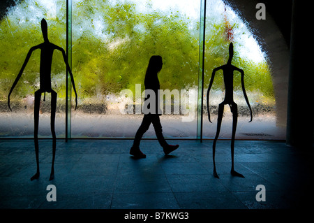 Ein Besucher, der National Gallery of Victoria in Melbourne vorbei an Silhouette Skulpturen in der Galerie foyer Stockfoto