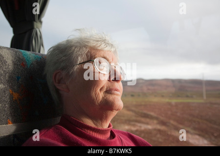 Müde senior Frau schlafend auf einem Trainer Sitz durch ein Fenster während der Fahrt auf einer langen Reise. Stockfoto