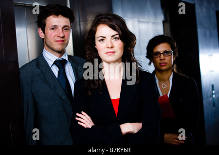 Porträt von glücklich erfolgreiches Team posiert auf Büro-Lobby vor dunklem Hintergrund Aufzug Stockfoto