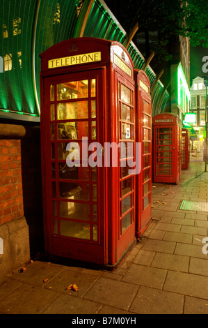 Eine Reihe von roten Telefonzellen in London bei Nacht Stockfoto