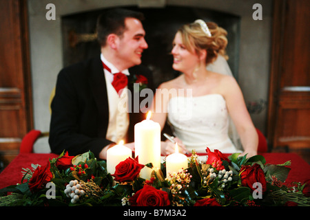 Braut und Bräutigam am Tag der Hochzeit standesamtliche Trauung Unterzeichnung registrieren im Hintergrund mit Weihnachten festlich Blume Display im Vordergrund Stockfoto