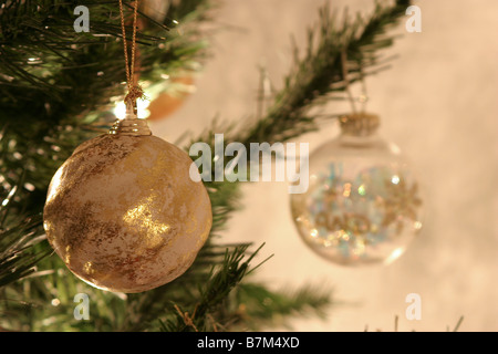 Nahaufnahme von 2 Baubels an einem Weihnachtsbaum hängen Stockfoto