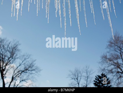 Hängende Eiszapfen vom Dach des Hauses Wintersaison mit blauem Himmel verschwommener unscharfer Hintergrund niedriger Winkel niemand horizontal in den USA US Hi-res Stockfoto