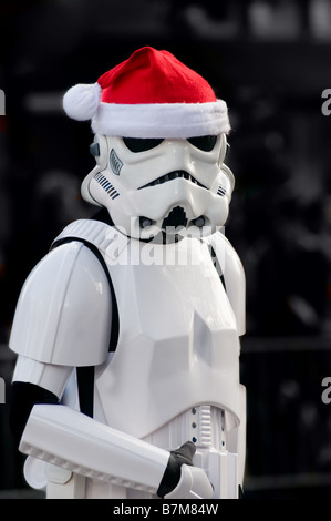 Star Wars Storm Trooper trägt eine Weihnachtsmann-Mütze während des Gehens in einer Ferien-Parade. Stockfoto