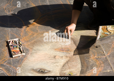 Eine Künstlerin zeichnen das Porträt einer Frau, die mit Kreide auf dem Bürgersteig in Florenz, Italien Stockfoto