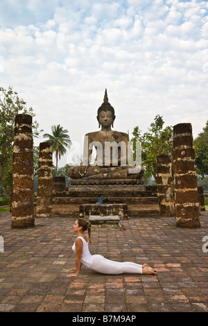 Yoga, Frau, Buddha, beim Yoga vor Denkmal, Sakralraum, Yogi, Yoga-Pose, zurück biegen, glückliches, gesundes, gut sein, weisen Stockfoto